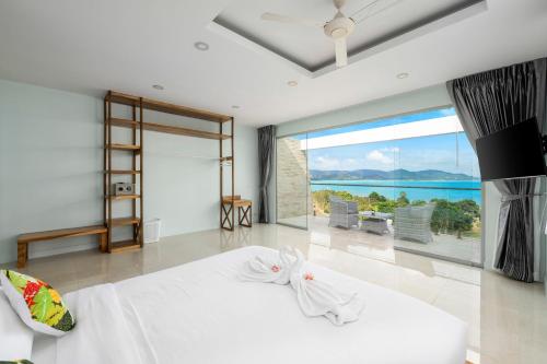 a bedroom with a bed with a view of the ocean at Sunset Lagoon Villa Rihanna in Bangrak Beach