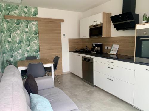 une cuisine avec un canapé et une table dans l'établissement Casita: votre oasis de détente, à Sérignan