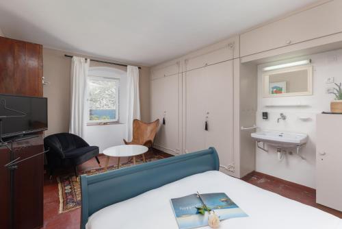 a bedroom with a bed and a sink and a table at Villa Blue Dream in Dobrota