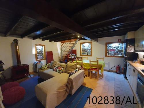 a living room with a couch and a kitchen at Casa Mega Fundeira, natureza e praia fluvial in Pedrógão Grande