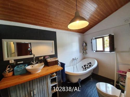 a bathroom with two sinks and a tub and a mirror at Casa Mega Fundeira, natureza e praia fluvial in Pedrógão Grande