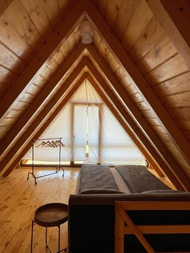 a room with a bed and a chair in a attic at Chalet Licina - Bjelašnica in Klanac