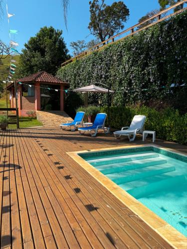 a swimming pool with two lounge chairs and a swimming pool at Pousada Shangri-lá in Cunha