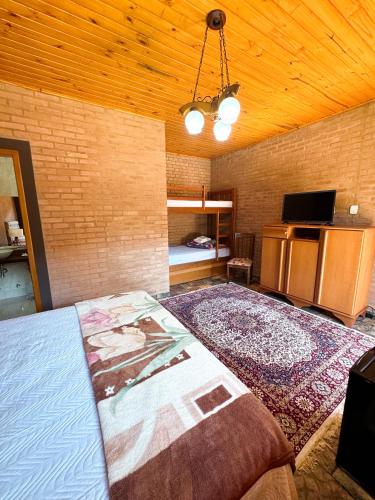 a bedroom with a bed with a painting on it at Pousada Shangri-lá in Cunha