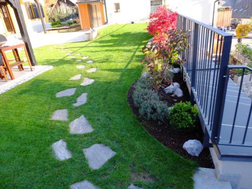 a garden with a fence and some grass and flowers at Vila Mila in Bled