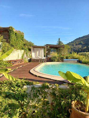 une piscine avec une terrasse en bois à côté d'une maison dans l'établissement Un coin d'Asie en Provence, à Belgentier
