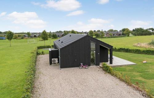 a black house with a bike parked in front of it at 3 Bedroom Beautiful Home In Haderslev in Haderslev
