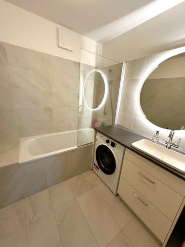 a bathroom with a washing machine and a sink at COHO City Apartments mit hauseigener Tiefgarage in Vienna