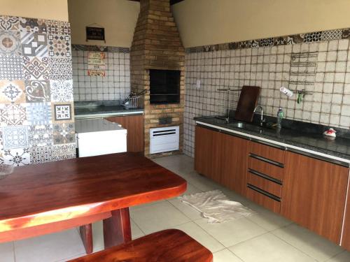 a kitchen with wooden cabinets and a counter top at Cantinho do Abaís, Condominio Meridiem Praia Mar in Praia Da Caueira