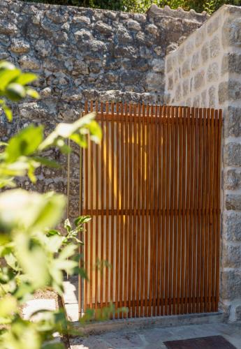 a wooden gate in front of a stone wall at Villa Blue Dream in Dobrota