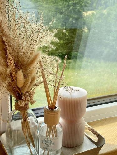 two vases with dried flowers in them on a window sill at Rajski Zakątek - jeden domek na działce z gorącą balią i mini ZOO in Kamionka Wielka