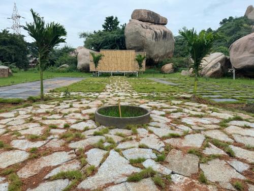 a park with a bench in the middle of a rock garden at Hill Stone View Hampi in Hampi