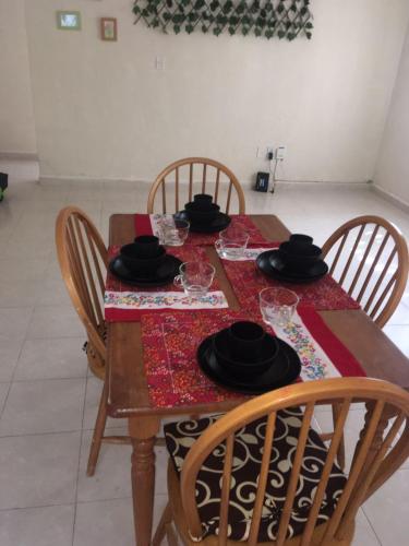 a wooden table with chairs and glasses on it at Town House, ideal para relajarse in Playa del Carmen