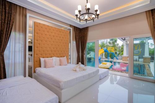 a bedroom with two beds and a large window at Bunny House Pool Villa Na Jomtien in Na Jomtien