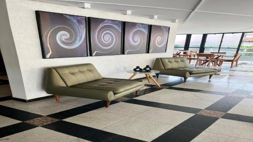 a lobby with two couches and a table and chairs at Classe Apart Hotel in Feira de Santana