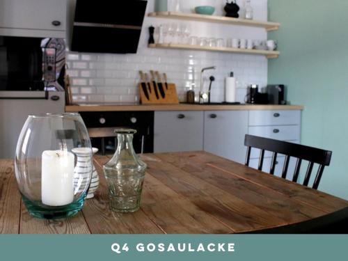 a wooden table with a glass vase and a candle on it at Dachstein 7 in Gosau