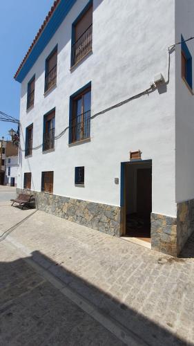 a large white building with a door in front of it at Apartamentos turísticos Pura Vida in Torrechiva
