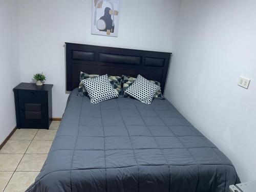 a bedroom with a bed with blue sheets and pillows at Alojamiento Puente Alto in Santiago