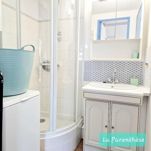 une salle de bain blanche avec une douche et un lavabo dans l'établissement La Parenthèse, à Pornic