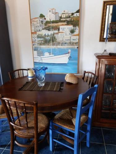 a dining room table with chairs and a table with a boat at Semi's House in Batsi