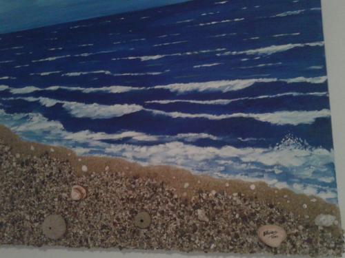 a painting of the ocean with rocks on the beach at Semi's House in Batsi