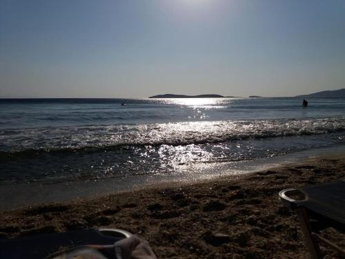 a beach with the sun reflecting on the water at Semi's House in Batsi