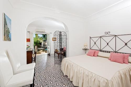una camera da letto con letto e cuscini rosa di Il Giardino dell'Arte ad Anacapri