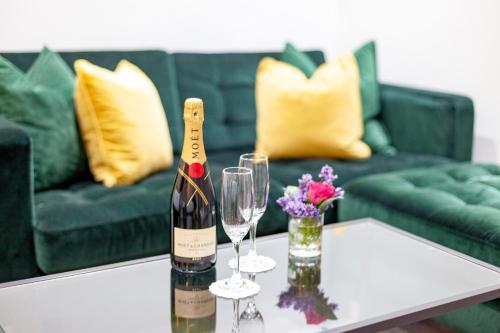a bottle of wine and two glasses on a table at Hotel Shepherds Bush London in London