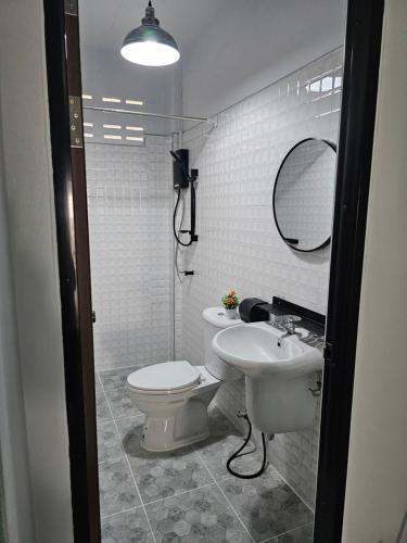 a bathroom with a sink and a toilet and a mirror at 34house in Betong