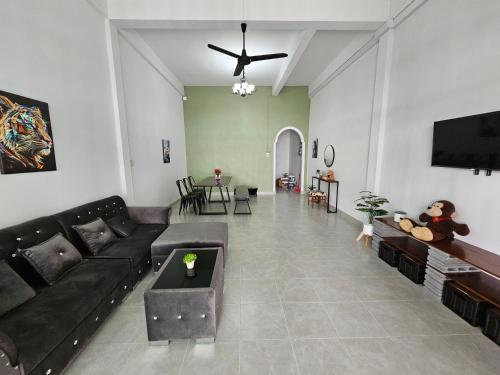 a living room with a couch and a flat screen tv at 34house in Betong