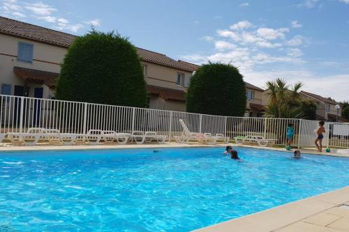 une personne nageant dans une grande piscine bleue dans l'établissement Le Lotus Bleu, à Pornic