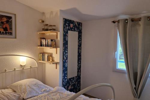 Un dormitorio con una cama, una ventana y un espejo. en Le Lotus Bleu, en Pornic