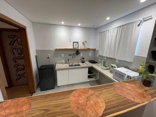 a kitchen with a sink and a counter top at Studios Aromas do Campeche - Floripa in Florianópolis