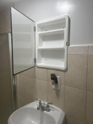 a bathroom sink with an open cabinet above it at VILLA GUILLA in Miami
