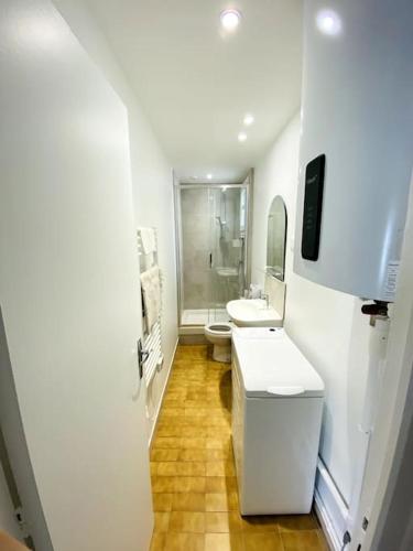 La salle de bains blanche est pourvue de 2 lavabos et de toilettes. dans l'établissement Maj Appart Iéna - Paris 16, à Paris