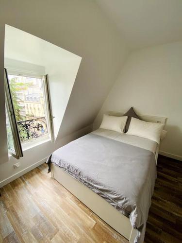 une chambre blanche avec un lit avec une fenêtre dans l'établissement Maj Appart Iéna - Paris 16, à Paris
