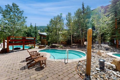 a swimming pool with two chairs and a table at Copper Mountain Ski Hideaway in Copper Mountain