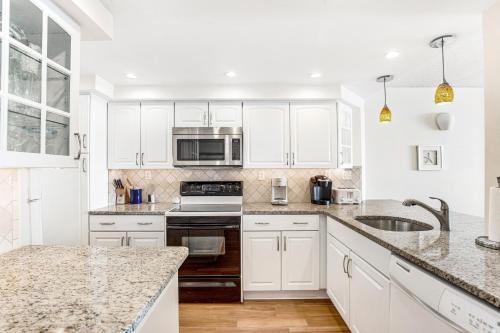a kitchen with white cabinets and marble counter tops at Sea Colony - 604 Dover House Rd. in Bethany Beach