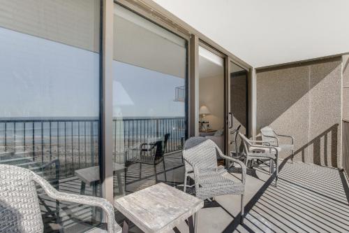 a balcony with chairs and tables and a view of the ocean at Sea Colony - 604 Dover House Rd. in Bethany Beach