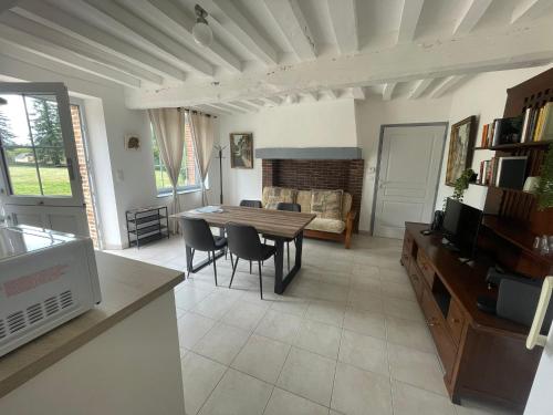 a living room with a table and a couch at Gîtes du Country Club R&S in La Puisaye