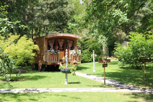 an old trolley car in a park with trees at Les roulottes a Sandie in Thionville
