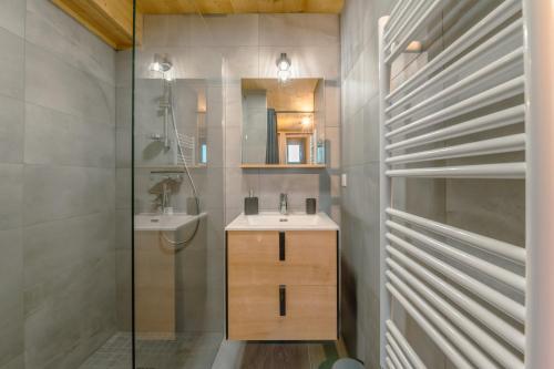 une salle de bain avec un lavabo, un miroir et une douche dans l'établissement Etoile des Vents 1, à Morzine