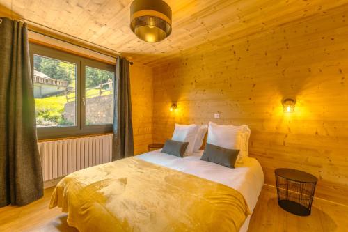 une chambre avec un lit dans une pièce en bois dans l'établissement Etoile des Vents 1, à Morzine
