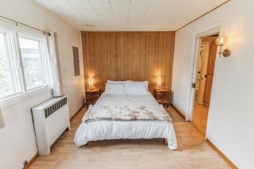 a bedroom with a bed with white sheets and pillows at Parkstrip Place, Pet Friendly Downtown Home in Anchorage