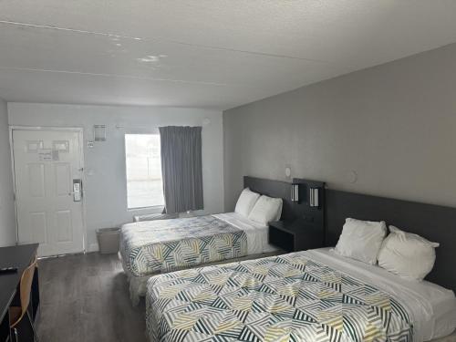 a hotel room with two beds and a desk at Motel 6-Norfolk, VA in Norfolk