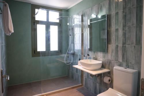 a bathroom with a sink and a toilet and a window at Xenion1850 culture and living in Vrontádos