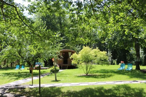 a gazebo in a park with chairs and trees at Les roulottes a Sandie in Thionville
