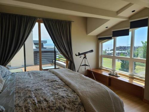 een slaapkamer met een bed met een camera en ramen bij The Seaside Getaway in Point Roberts