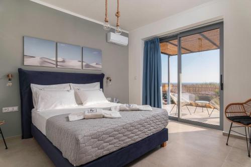 イエラペトラにあるBelvedere Villaの大きなベッドとバルコニーのある寝室