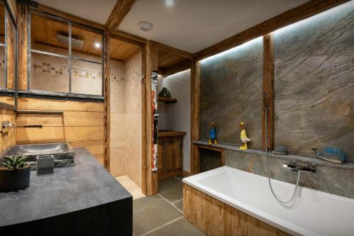 une salle de bain avec une baignoire et un lavabo dans l'établissement Chalet K1027 - OVO Network, à Cordon